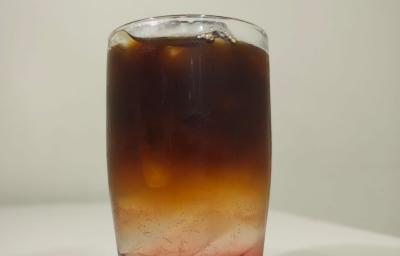 Foto da receita de espresso tonica com amora servida em um copo de vidro alto sobre uma mesa branca Foto da receita de espresso tonica com amora servida em um copo de vidro alto sobre uma mesa branca