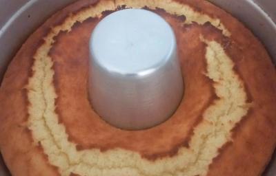 Foto da receita de Bolo de Arroz Cru. Observa-se um bolo assado ainda dentro de uma forma com furo no meio Foto da receita de Bolo de Arroz Cru. Observa-se um bolo assado ainda dentro de uma forma com furo no meio