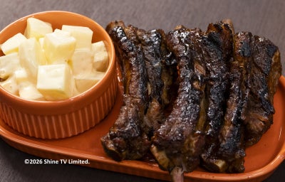 Costelinhas ao barbecue grelhadas com salada de batata cremosa em prato laranja