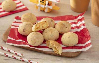 Fotografia em tons de vermelho com vários pães de queijo feitos com NINHO Primeira Infância ao centro. Fotografia em tons de vermelho com vários pães de queijo feitos com NINHO Primeira Infância ao centro.