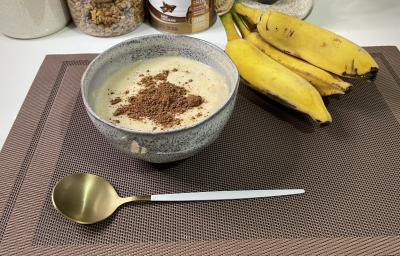 Imagem da receita de Mingau Proteico em um bowl, sobre uma mesa e ao lado uma banana e colher Imagem da receita de Mingau Proteico em um bowl, sobre uma mesa e ao lado uma banana e colher