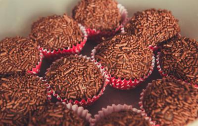 Fotografia de várias unidades de brigadeiro, passados no granulado dentro de forminhas vermelhas com bolinhas brancas. Fotografia de várias unidades de brigadeiro, passados no granulado dentro de forminhas vermelhas com bolinhas brancas.