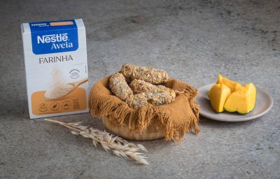 Foto receita de Croquete Vegetariano, servidos em uma cesta de vime, sobre uma bancada de mármore onde há uma caixa de nestlé farinha de aveia à esquerda e pedaços de abóbora sobre um prato à direita além de um ramo de trigo à frente Foto receita de Croquete Vegetariano, servidos em uma cesta de vime, sobre uma bancada de mármore onde há uma caixa de nestlé farinha de aveia à esquerda e pedaços de abóbora sobre um prato à direita além de um ramo de trigo à frente