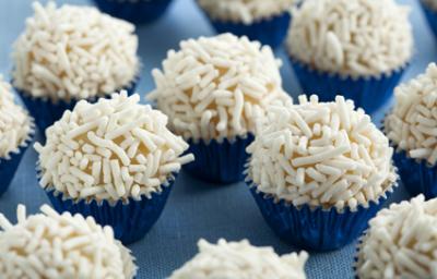Fotografia em tons de branco e azul de vários brigadeiros em forminhas azuis metalizadas com granulado branco. Fotografia em tons de branco e azul de vários brigadeiros em forminhas azuis metalizadas com granulado branco.