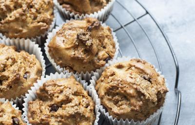 Fotografia de sete muffins com chocolate branco e preto em uma forminha de papel branca, que estão em cima de uma grade redonda na cor preta. Os bolinhos estão sobre uma mesa de cor clara. Fotografia de sete muffins com chocolate branco e preto em uma forminha de papel branca, que estão em cima de uma grade redonda na cor preta. Os bolinhos estão sobre uma mesa de cor clara.