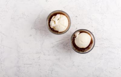 Fotografia vista de cima de dois recipientes pequenos de vidro com affogato delicioso feito com Prestígio Morango, sorvete de creme e NESCAFÉ. Os recipientes estão sobre uma mesa de mármore branca. Fotografia vista de cima de dois recipientes pequenos de vidro com affogato delicioso feito com Prestígio Morango, sorvete de creme e NESCAFÉ. Os recipientes estão sobre uma mesa de mármore branca.