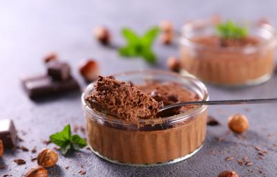 Fotografia em tons de azul com um pote de vidro ao centro. Dentro do pote existe uma mousse de chocolate feita com nescau Fotografia em tons de azul com um pote de vidro ao centro. Dentro do pote existe uma mousse de chocolate feita com nescau