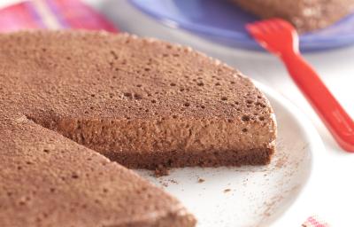 fotografia em tons de azul e marrom tirada de uma torta de chocolate com uma fatia retirada, e ao fundo um prato redondo azul com um pedaço da torta fotografia em tons de azul e marrom tirada de uma torta de chocolate com uma fatia retirada, e ao fundo um prato redondo azul com um pedaço da torta