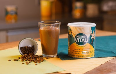 imagem mostra um copo de refresco de café cremoso, com coloração marrom e acabamento de canela