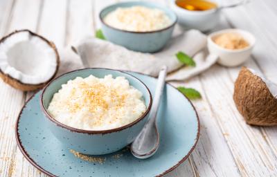 Foto da receita de Doce de Coco. Observa-se o doce em uma vasilha de cerâmica azul bebê, sobre um pires da mesma cor. Cocos cortados ao meio decoram a foto. Foto da receita de Doce de Coco. Observa-se o doce em uma vasilha de cerâmica azul bebê, sobre um pires da mesma cor. Cocos cortados ao meio decoram a foto.