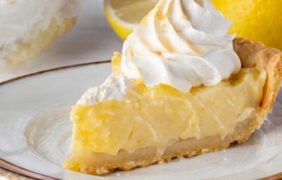 Fotografia de um pedaço de torta de limão com merengue em um prato raso grande. Fotografia de um pedaço de torta de limão com merengue em um prato raso grande.