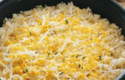Uma panela comporta o arroz em tons amarelos. Uma panela comporta o arroz em tons amarelos.