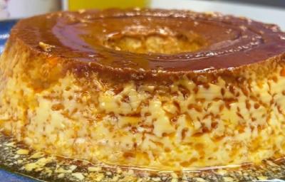 Foto da receita de pudim de leite moça na panela servida em uma porção grande sobre uma bancada cinza Foto da receita de pudim de leite moça na panela servida em uma porção grande sobre uma bancada cinza
