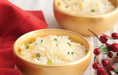 Fotografia em tons de vermelho em uma mesa de madeira com uma toalha branca e um pano vermelho ao lado. Ao centro, um prato fundo dourado com o arroz feito com vinho branco. Fotografia em tons de vermelho em uma mesa de madeira com uma toalha branca e um pano vermelho ao lado. Ao centro, um prato fundo dourado com o arroz feito com vinho branco.