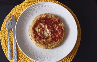 Imagem da receita de Pão de Queijo de Frigideira com Crostinha, em um prato branco, e ao lado os talheres Imagem da receita de Pão de Queijo de Frigideira com Crostinha, em um prato branco, e ao lado os talheres