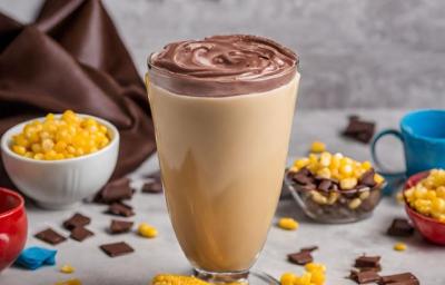 Fotografia de um copo alto com um creme amarelo, com uma cobertura de chocolate. Fotografia de um copo alto com um creme amarelo, com uma cobertura de chocolate.