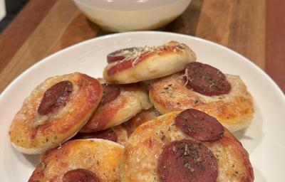 Fotografia de várias mini pizzas dentro de um prato de vidro branco fundo sobre uma tábua de madeira. Fotografia de várias mini pizzas dentro de um prato de vidro branco fundo sobre uma tábua de madeira.