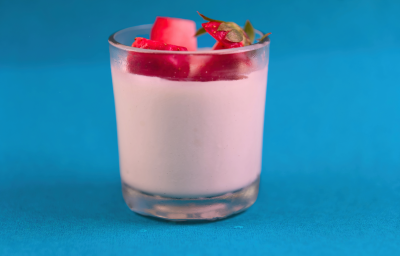Uma deliciosa mousse de morango com uma textura cremosa e suave, decorada com morangos frescos e servida em copo.