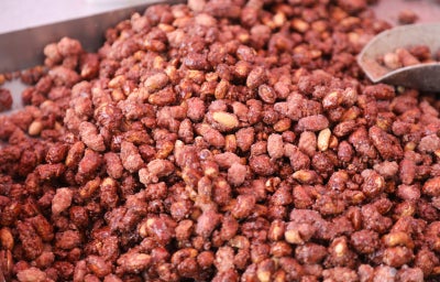 Imagem mostra uma porção de amendoins doces com camada crocante e rosada de açúcar
