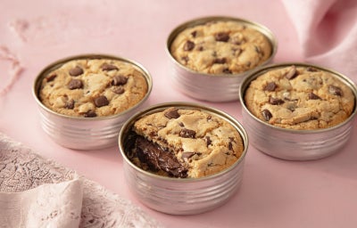 imagem mostra uma lata de alumínio contendo uma massa de cookie dentro com gotas de chocolate