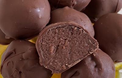 Fotografia em tons de amarelo com um prato amarelo ao centro. Em cima do prato existe uma receita de trufas de chocolate com laranja cobertas com chocolate ao leite Fotografia em tons de amarelo com um prato amarelo ao centro. Em cima do prato existe uma receita de trufas de chocolate com laranja cobertas com chocolate ao leite