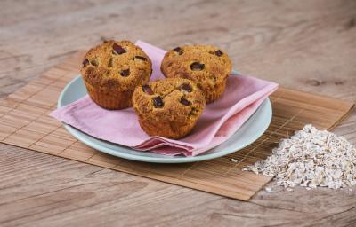 Foto da receita de Muffin de Maçã e Manga. Observa-se 3 muffins em cima de um guardanapo rosa e um prato azul. Foto da receita de Muffin de Maçã e Manga. Observa-se 3 muffins em cima de um guardanapo rosa e um prato azul.