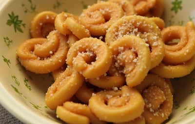 Recipiente redondo com biscoitos em meia lua e crocantes.