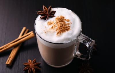Fotografia de uma xícara de vidro com uma bebida quente com leite MOÇA, chocolate em pó, NESCAFÉ, leite, cravo, canela. Fotografia de uma xícara de vidro com uma bebida quente com leite MOÇA, chocolate em pó, NESCAFÉ, leite, cravo, canela.