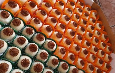 Foto da receita de Brigadeiro com Creme de Avelã. Observa-se inúmeros brigadeiros em forminhas dispostos em uma caixa decorados com creme de avelã em cima, feito com bico de confeiteiro Foto da receita de Brigadeiro com Creme de Avelã. Observa-se inúmeros brigadeiros em forminhas dispostos em uma caixa decorados com creme de avelã em cima, feito com bico de confeiteiro