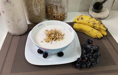 Imagem da receita de Iogurte Caseiro de Morango em um bowl, sobre uma mesa com bananas e uvas ao lado Imagem da receita de Iogurte Caseiro de Morango em um bowl, sobre uma mesa com bananas e uvas ao lado