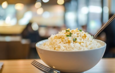 Em uma tigela branca, porção de arroz soltinho, decorado com cheiro-verde picado e alho frito. Em uma tigela branca, porção de arroz soltinho, decorado com cheiro-verde picado e alho frito.
