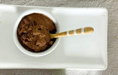 Foto em tons claros de cinza da receita de mousse de cacau com 3 ingredientes servida em um bowl de porcelana branco sobre uma base de porcelana de mesma cor. Foto em tons claros de cinza da receita de mousse de cacau com 3 ingredientes servida em um bowl de porcelana branco sobre uma base de porcelana de mesma cor.