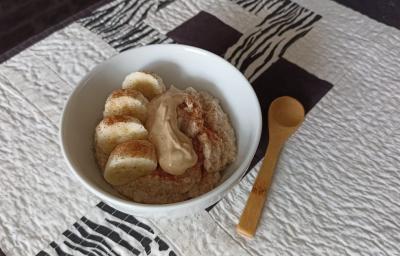 Imagem da receita de Mingau proteico pós treino, em um pote médio, sobre uma toalha e ao lado uma colher de madeira Imagem da receita de Mingau proteico pós treino, em um pote médio, sobre uma toalha e ao lado uma colher de madeira