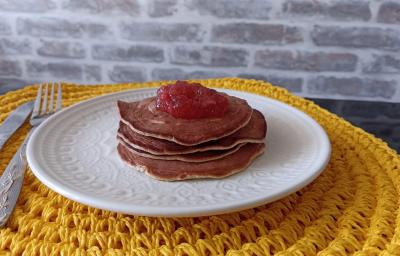 Imagem Imagem da receita de Panqueca Americana nutritiva com cobertura de geleia de frutas, em um prato branco, e ao lado os talheres Imagem Imagem da receita de Panqueca Americana nutritiva com cobertura de geleia de frutas, em um prato branco, e ao lado os talheres