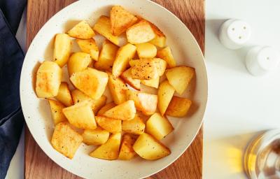 fotografia em tons de amarelo e branco de uma bancada branca vista de cima. Contém uma tábua de madeira marrom, por cima um recipiente redondo branco e dentro batatas picadas. fotografia em tons de amarelo e branco de uma bancada branca vista de cima. Contém uma tábua de madeira marrom, por cima um recipiente redondo branco e dentro batatas picadas.