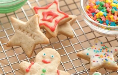 Fotografia de biscoitos decorados de natal em formato de boneco, estrela e presentes, nas cores vermelho, verde e branco, decorados com confeitos das mesmas cores. Fotografia de biscoitos decorados de natal em formato de boneco, estrela e presentes, nas cores vermelho, verde e branco, decorados com confeitos das mesmas cores.