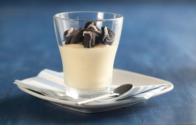 fotografia em tons de azul e branco de uma bancada azul vista de frente, contém um pratinho branco com um pano em tons de azul branco, um copo transparente com creme de maracujá com pedaços de biscoitos por cima. fotografia em tons de azul e branco de uma bancada azul vista de frente, contém um pratinho branco com um pano em tons de azul branco, um copo transparente com creme de maracujá com pedaços de biscoitos por cima.