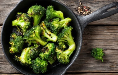 imagem mostra um recipiente com pedaços de brócolis verdes refogados