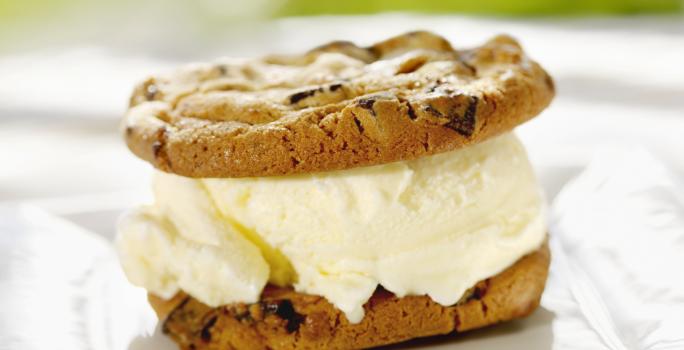 Fotografia de dois cookies e recheio de sorvete branco no meio.