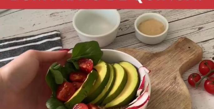 Foto da receita de Quinoa com Cogumelos. Observa-se um bowl com a quinoa em cima de uma tábua com uma mão segurando.