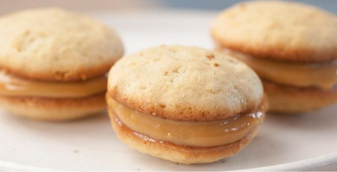 3 Whoopie de Banana com recheio de Doce de Leite por cima de um prato redondo e branco.