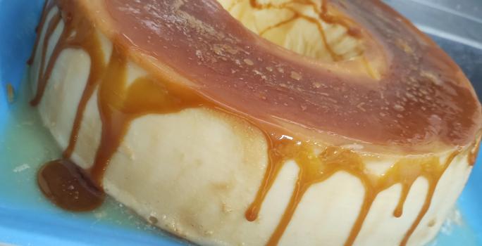 Foto da receita de Pudim Ligeiro. Observa-se um pudim com uma calda cor caramelo escorrendo.