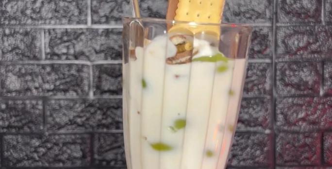 Fotografia de uma taça de vidro grande com cmadas de iogurte, choco trio e frutas.