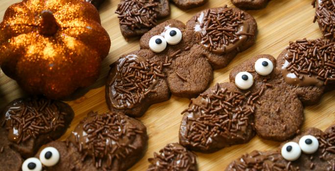Fotografia de varios biscoitos de chocolates em formato de morcego decorados com granulado.