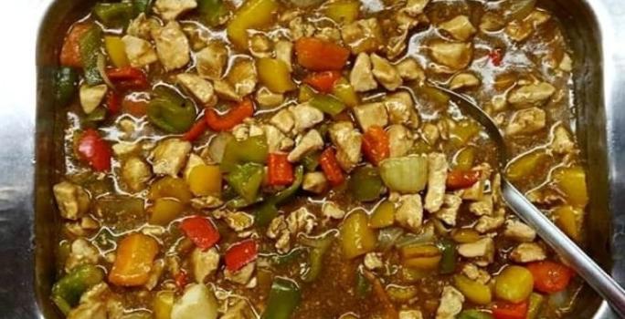 Foto da receita de Frango Xadrez. Observa-se um recipiente refratário com a receita dentro de frango e legumes com molho à base de shoyu.