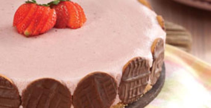 fotografia em tons de rosa e marrom tirada de uma torta de morango com biscoitos de chocolates em volta