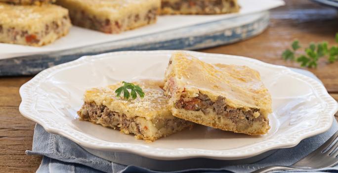 Foto de um prato branco com dois pedaços de torta de carne moída dentro.