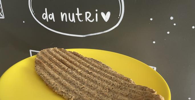 Imagem da receita de Pão de microondas sem glúten, em um prato amarelo e ao fundo uma lousa escrito em giz "Receita da nutri"