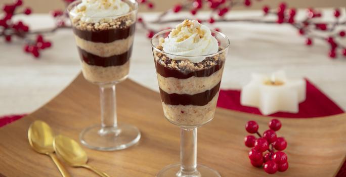 Fotografia de taças individuais mostrano camadas de creme de paçoca, chocolate e no topo chantilly com pedaços de paçoca triturado.