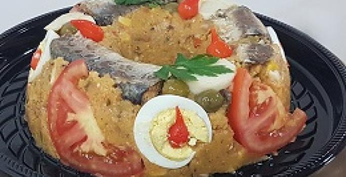 Foto da receita de Cuscuz Paulista Maravilhoso. Observa-se um cuscuz decorado com tomate, ovos, sardinha.